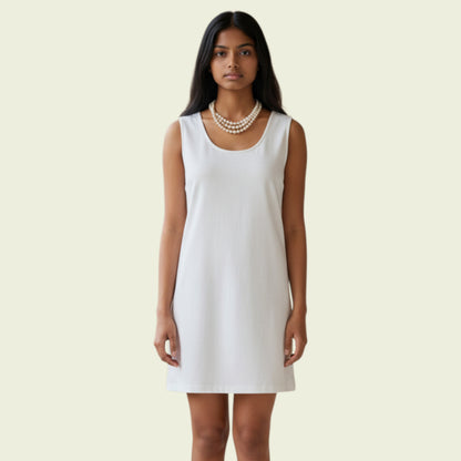 Model wearing a cream mini dress on a beige background