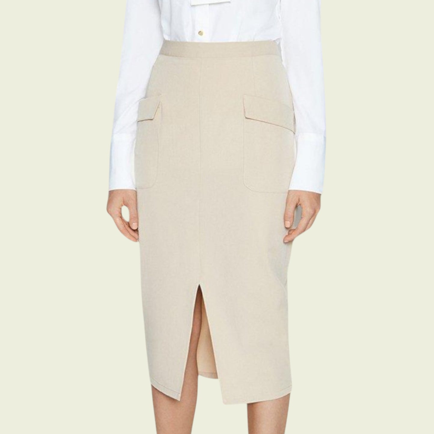 Beige pencil skirt worn with a white blouse on a light beige background
