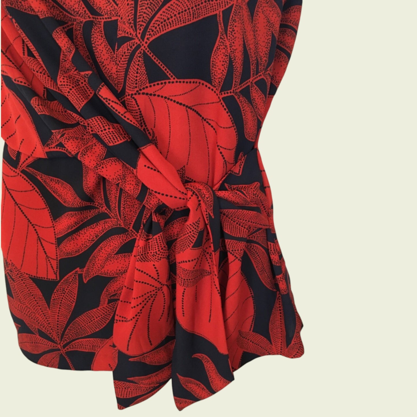 Red and black leaf-patterned fabric on a beige background