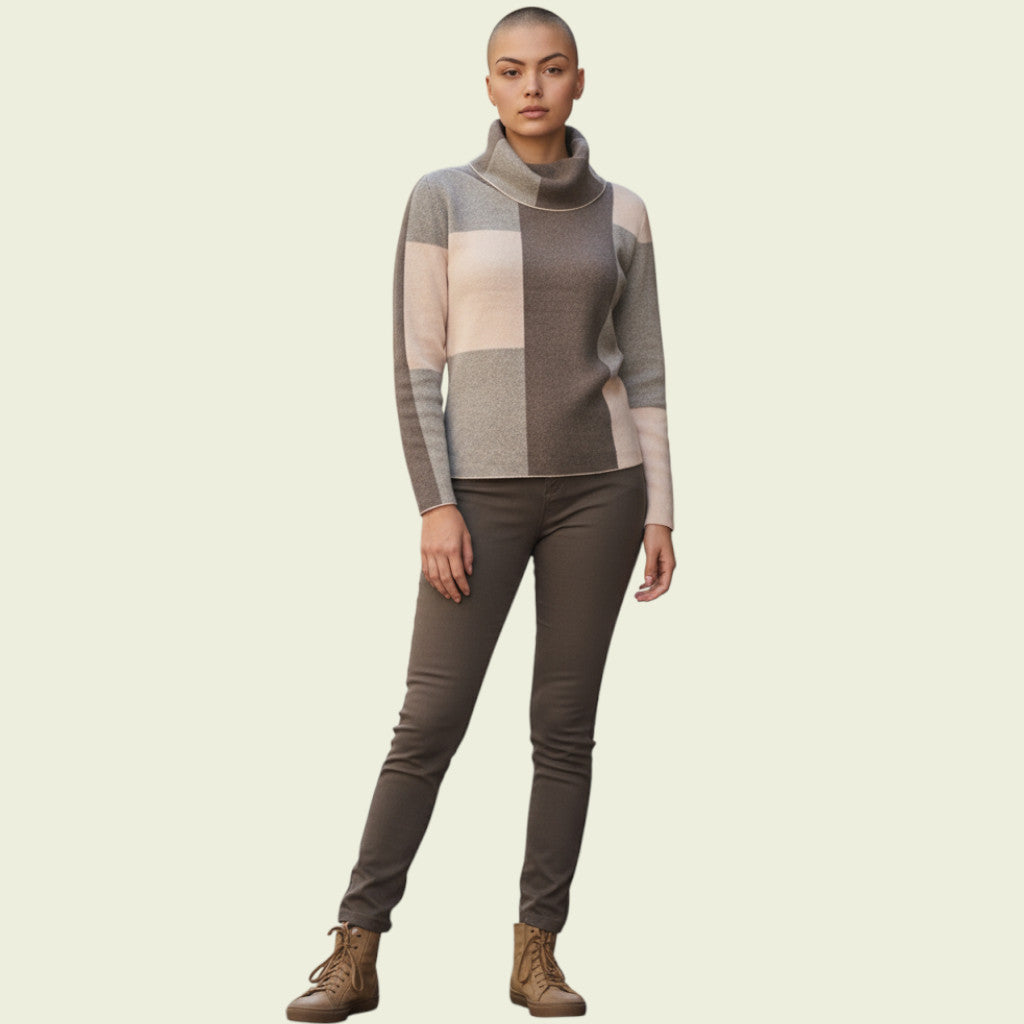 Person wearing a checkered sweater and dark pants on a beige background