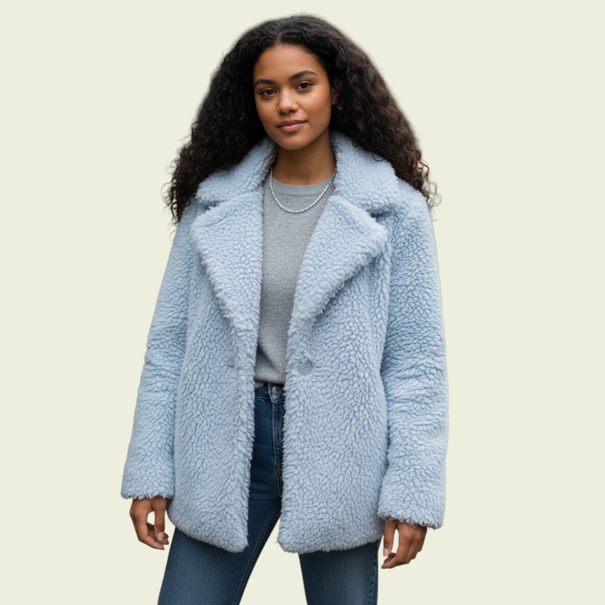 Woman wearing a light blue sherpa coat on a beige background