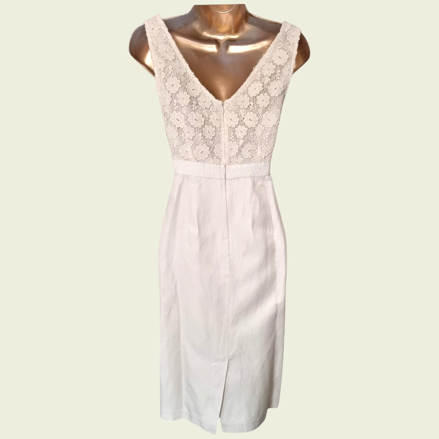 Mannequin wearing a cream dress with embroidered bodice on beige background