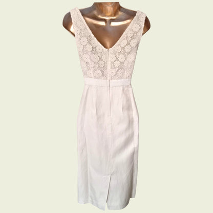 Mannequin wearing a cream dress with embroidered bodice on beige background