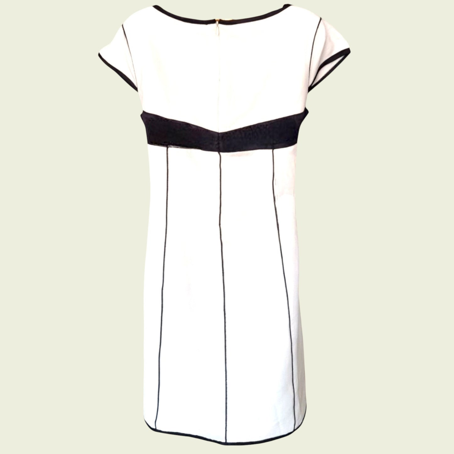 White dress with black accents on a beige background