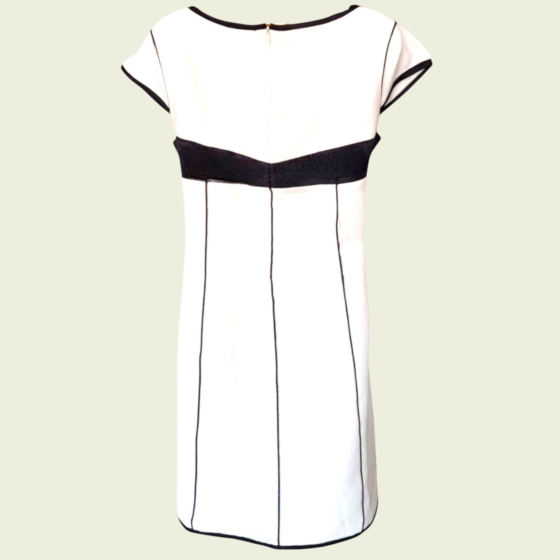 White dress with black accents on a beige background