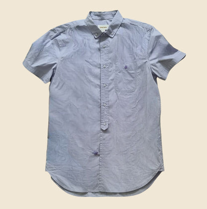 Lilac short-sleeve button-up shirt on a beige background