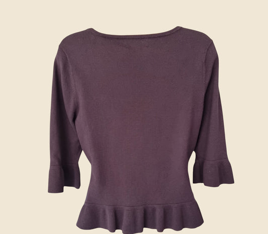Taupe sweater with ruffled hem on a beige background