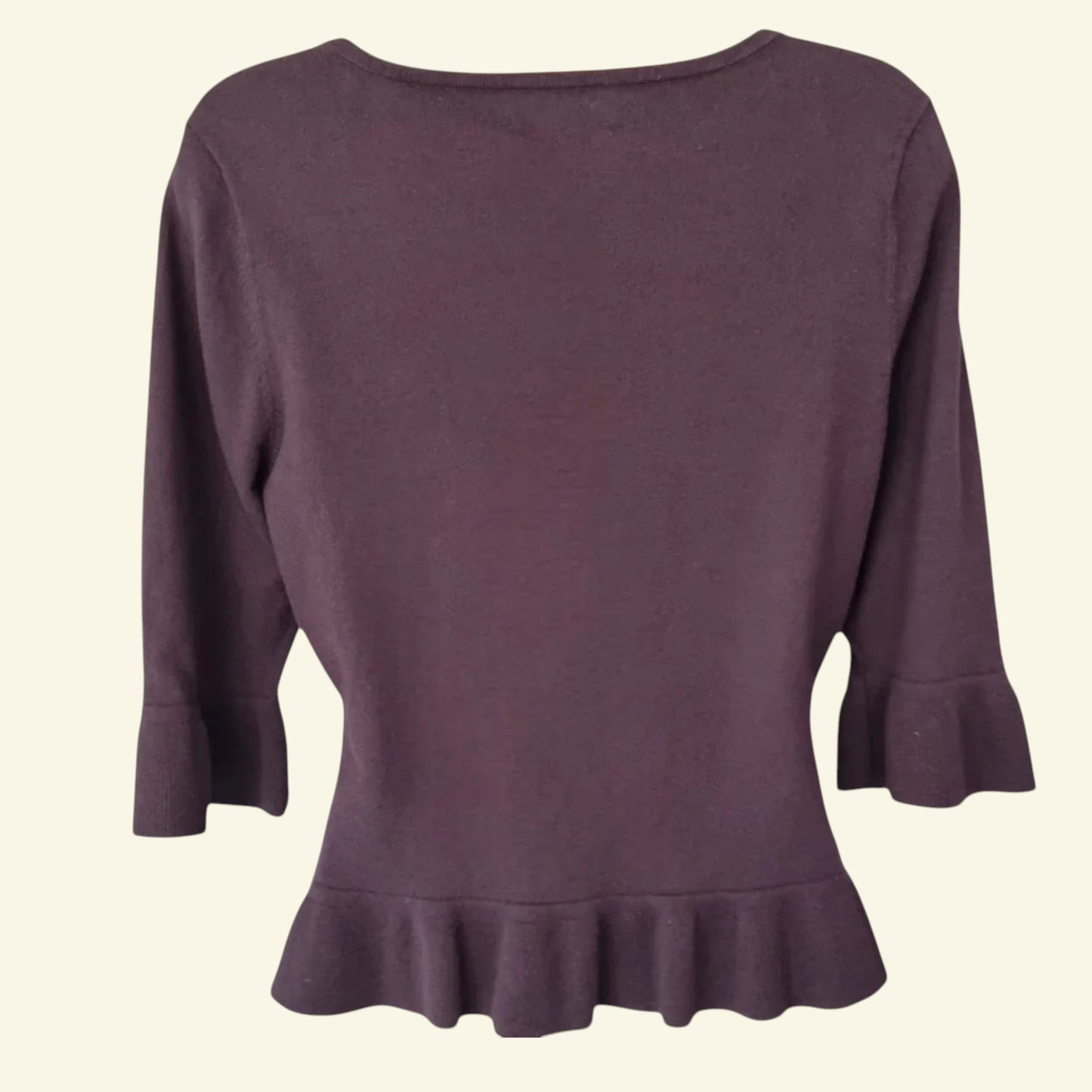 Brown sweater with ruffled hem on a beige background