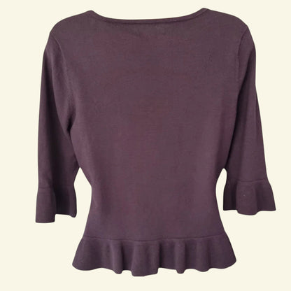 Brown sweater with ruffled hem on a beige background
