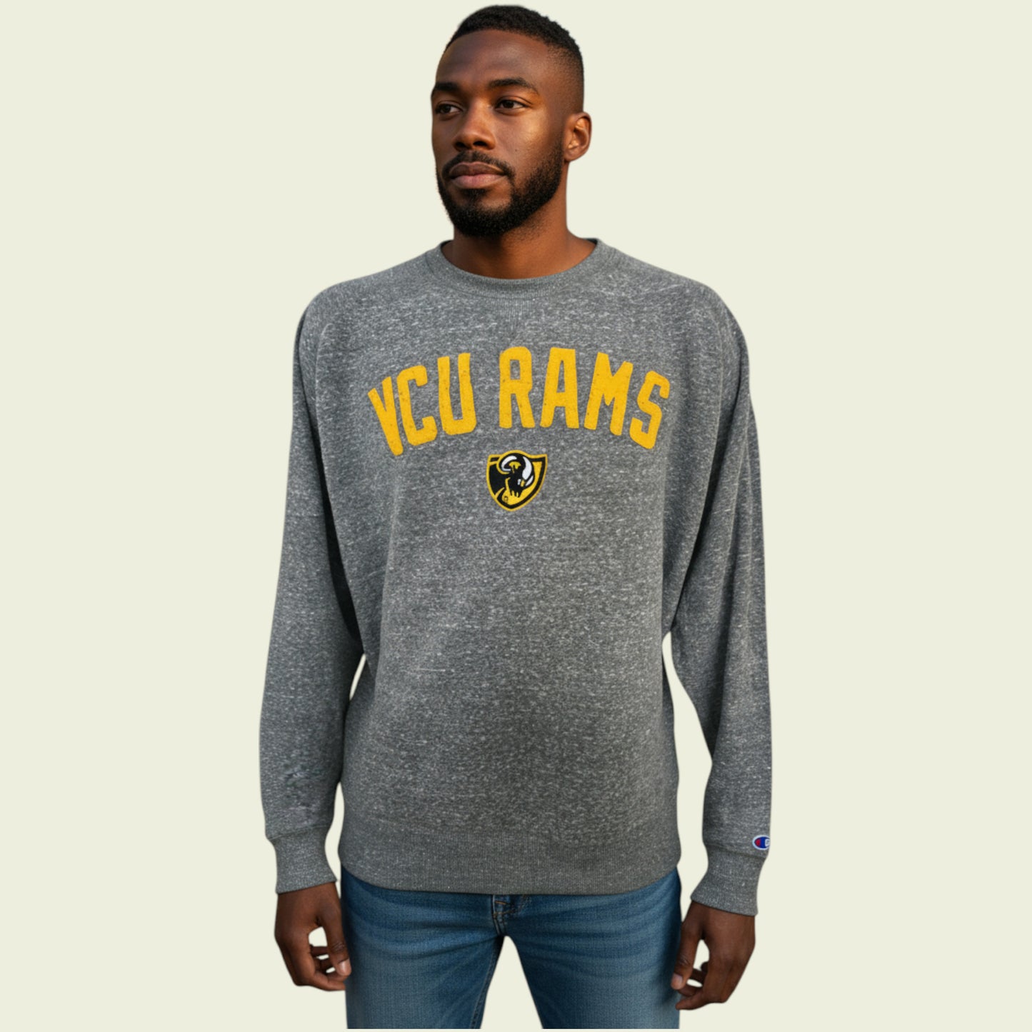 Man wearing a gray 'VCU Rams' sweatshirt on a beige background