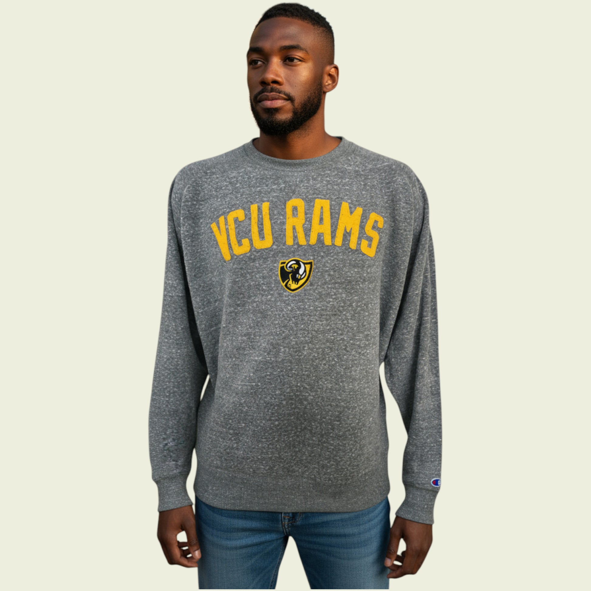 Man wearing a gray 'VCU Rams' sweatshirt on a beige background