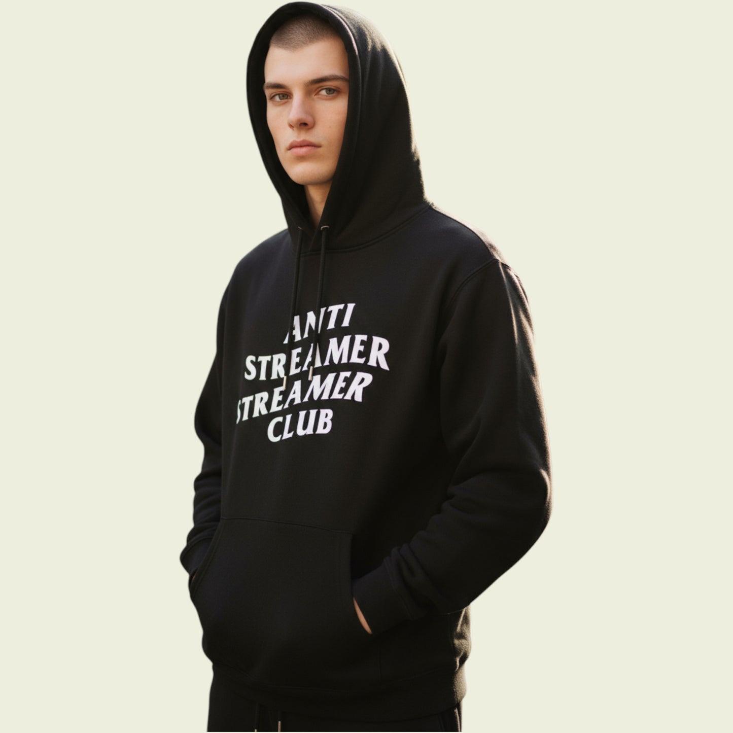 Person wearing a black hoodie with 'ANTI STREAMER STREAMER CLUB' text on a beige background
