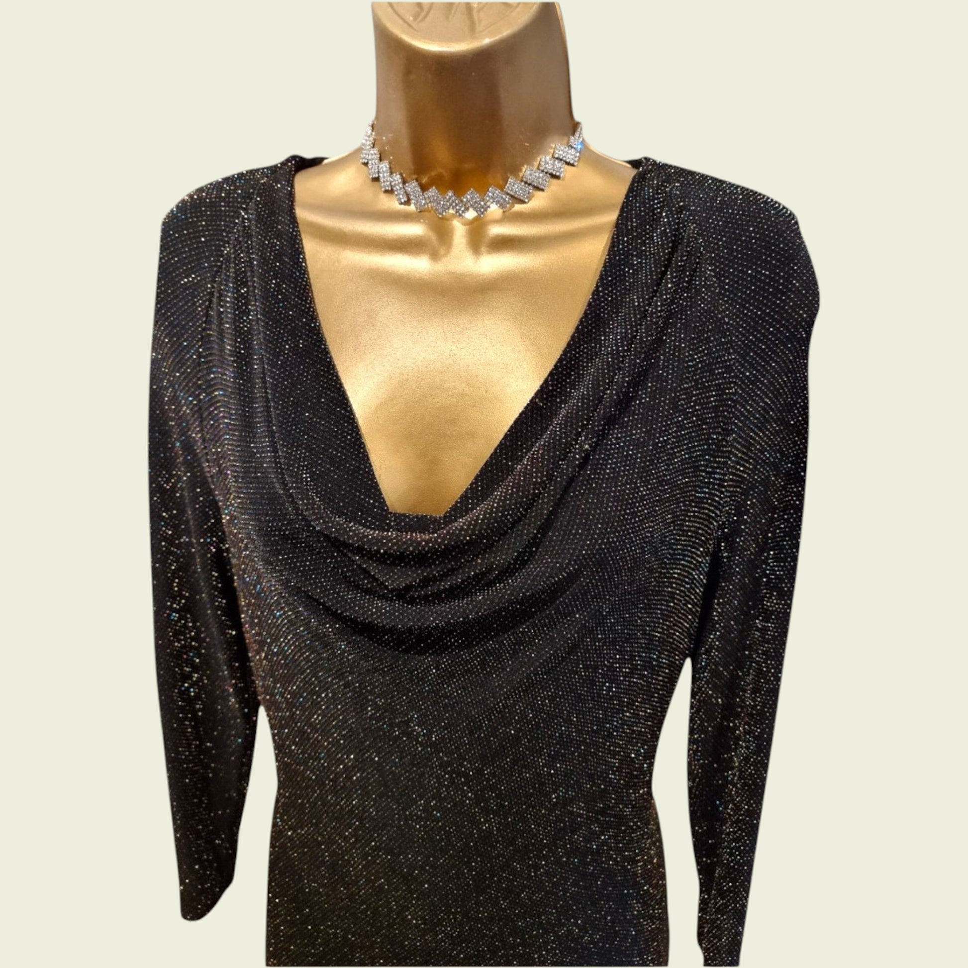 Black glittery dress on a mannequin with a necklace against a beige background