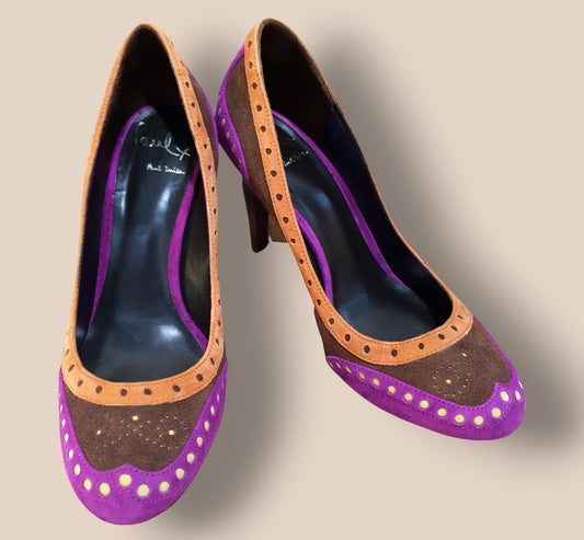 Purple high-heeled shoes with brown accents on a beige background