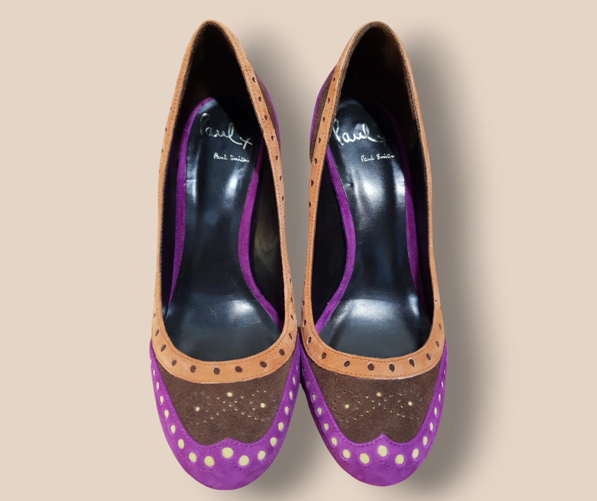 Purple and brown shoes with decorative elements on a beige background