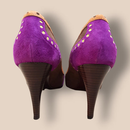 Purple high-heeled shoes with brown soles on a beige background