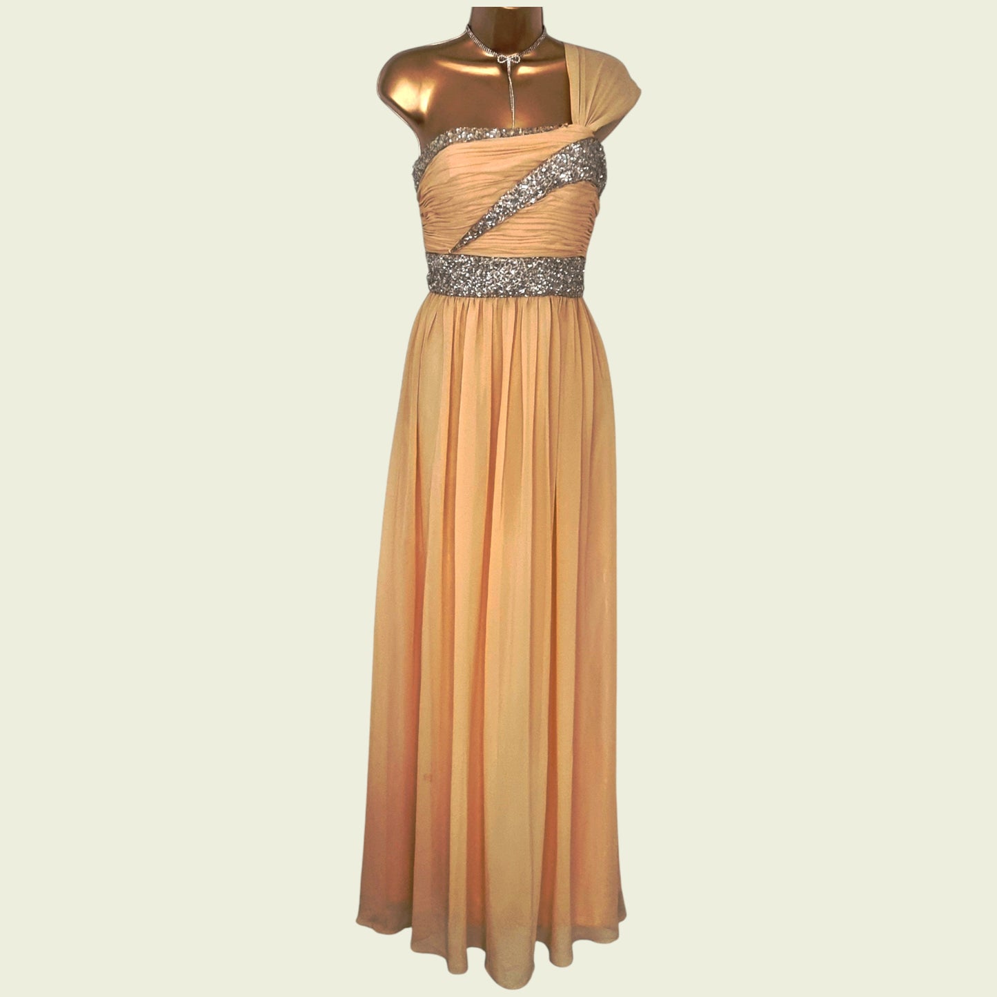 Beige evening gown with silver embellishments on a mannequin against a beige background