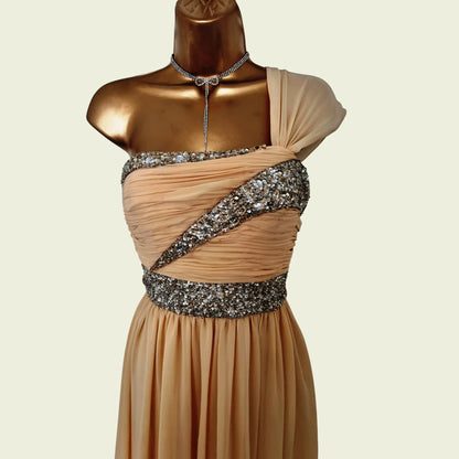 Beige evening gown with silver embellishments on a mannequin against a beige background