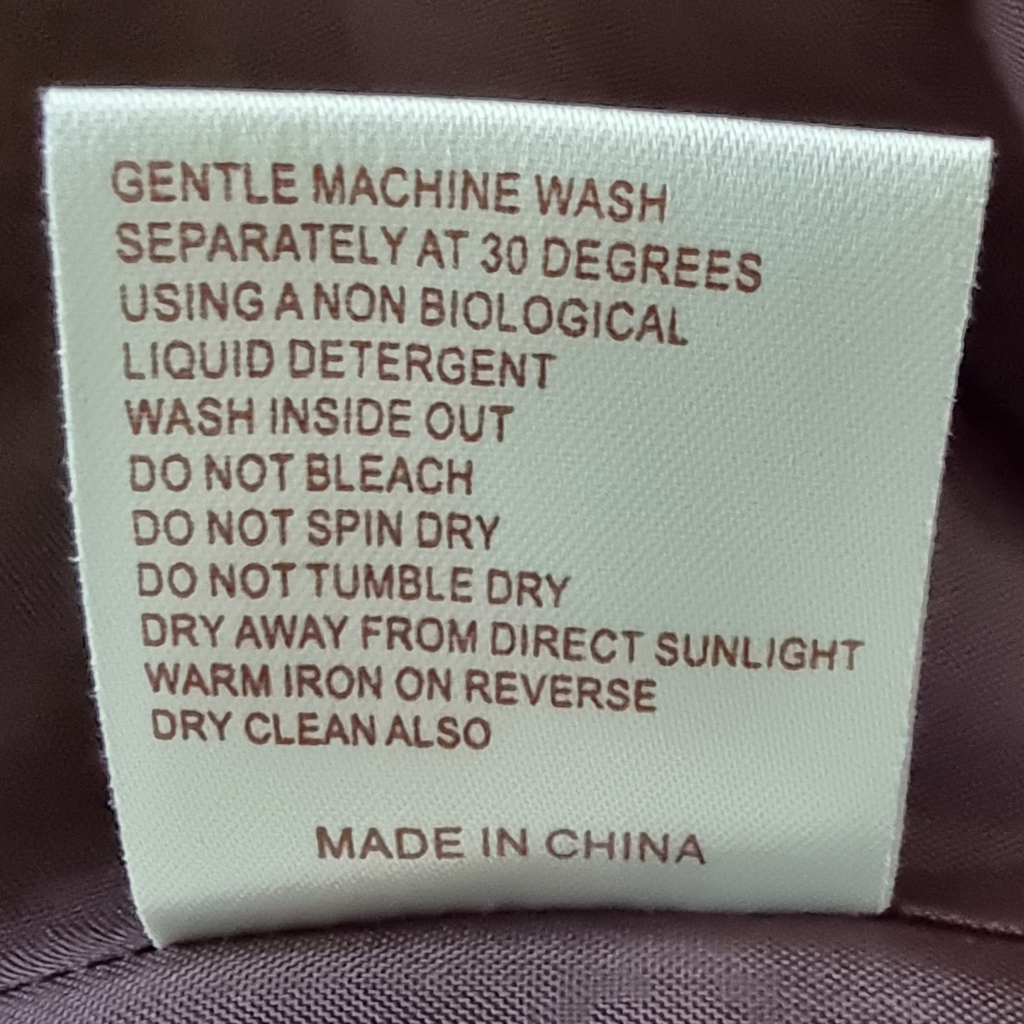 Clothing label with washing instructions on a fabric background
