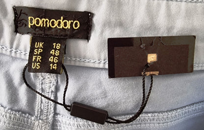 Close-up of clothing tags with brand name 'pomodoro' on a light fabric background