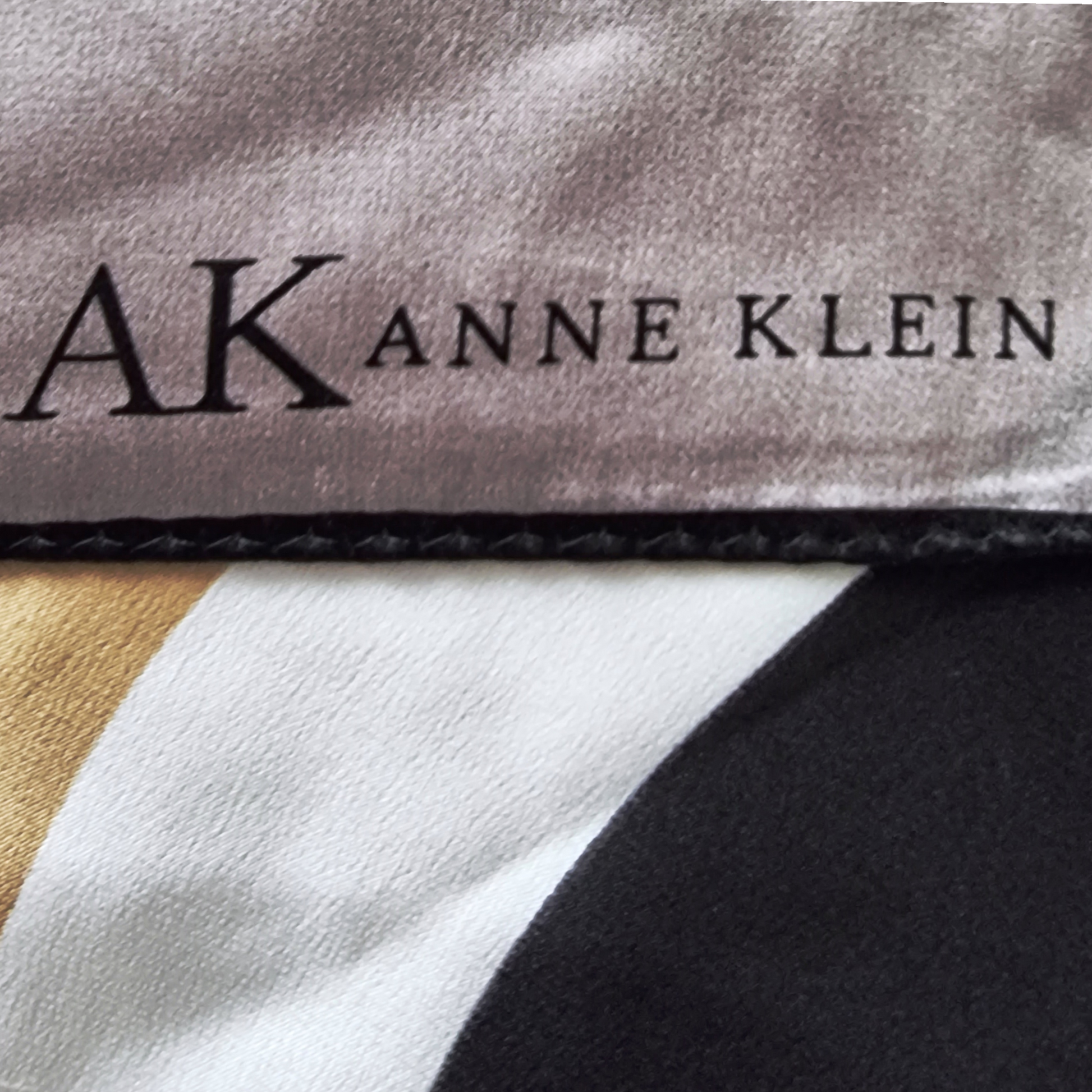 Close-up of Anne Klein label on fabric with color swatches.