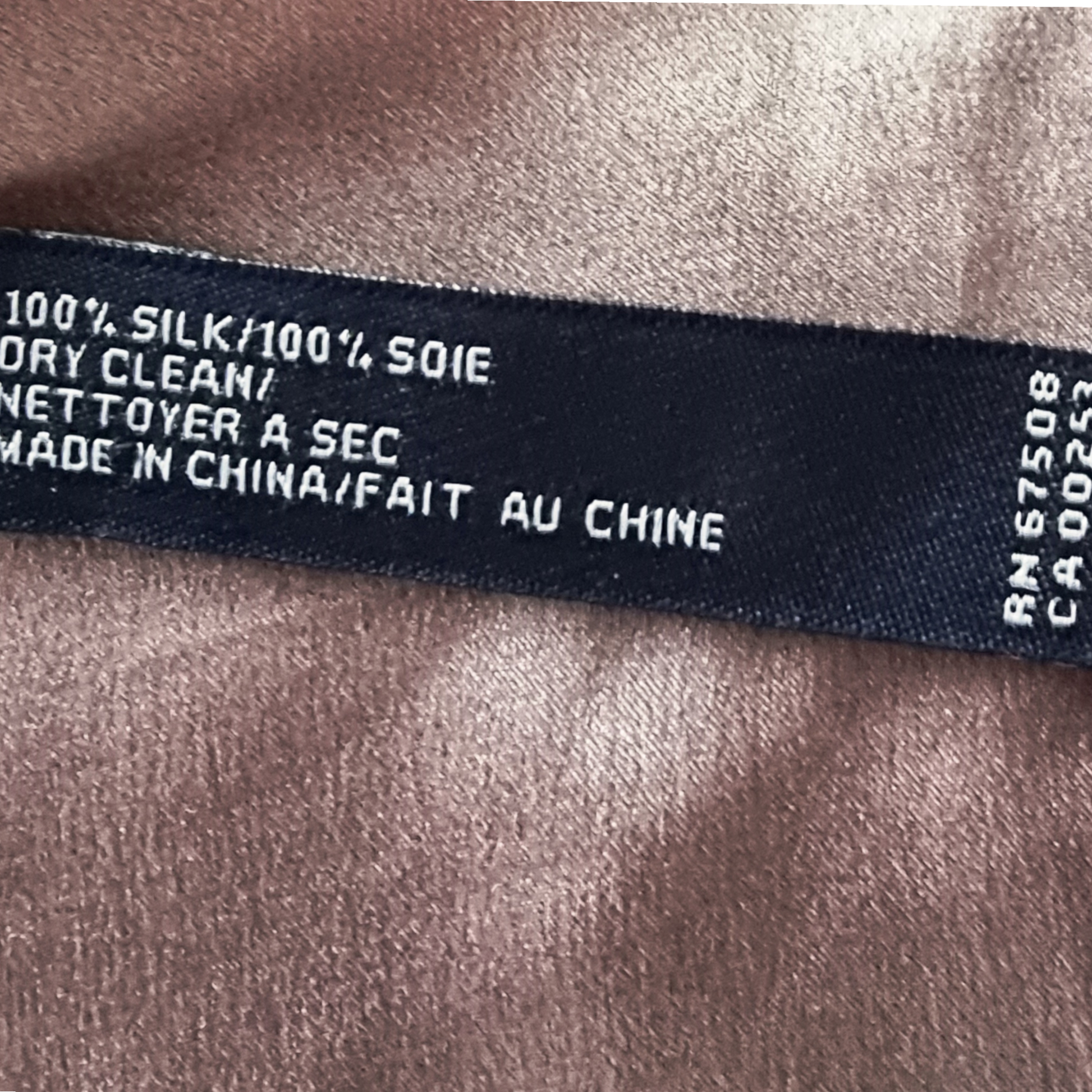 Text label on silk fabric indicating care instructions and origin.