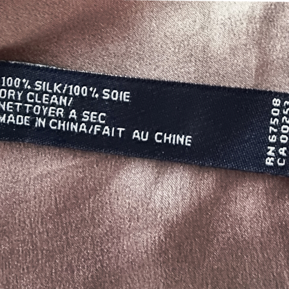 Text label on silk fabric indicating care instructions and origin.
