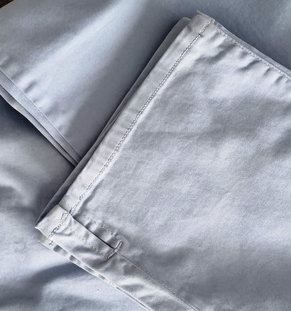 Close-up of light gray pants with a focus on hem slit detail.