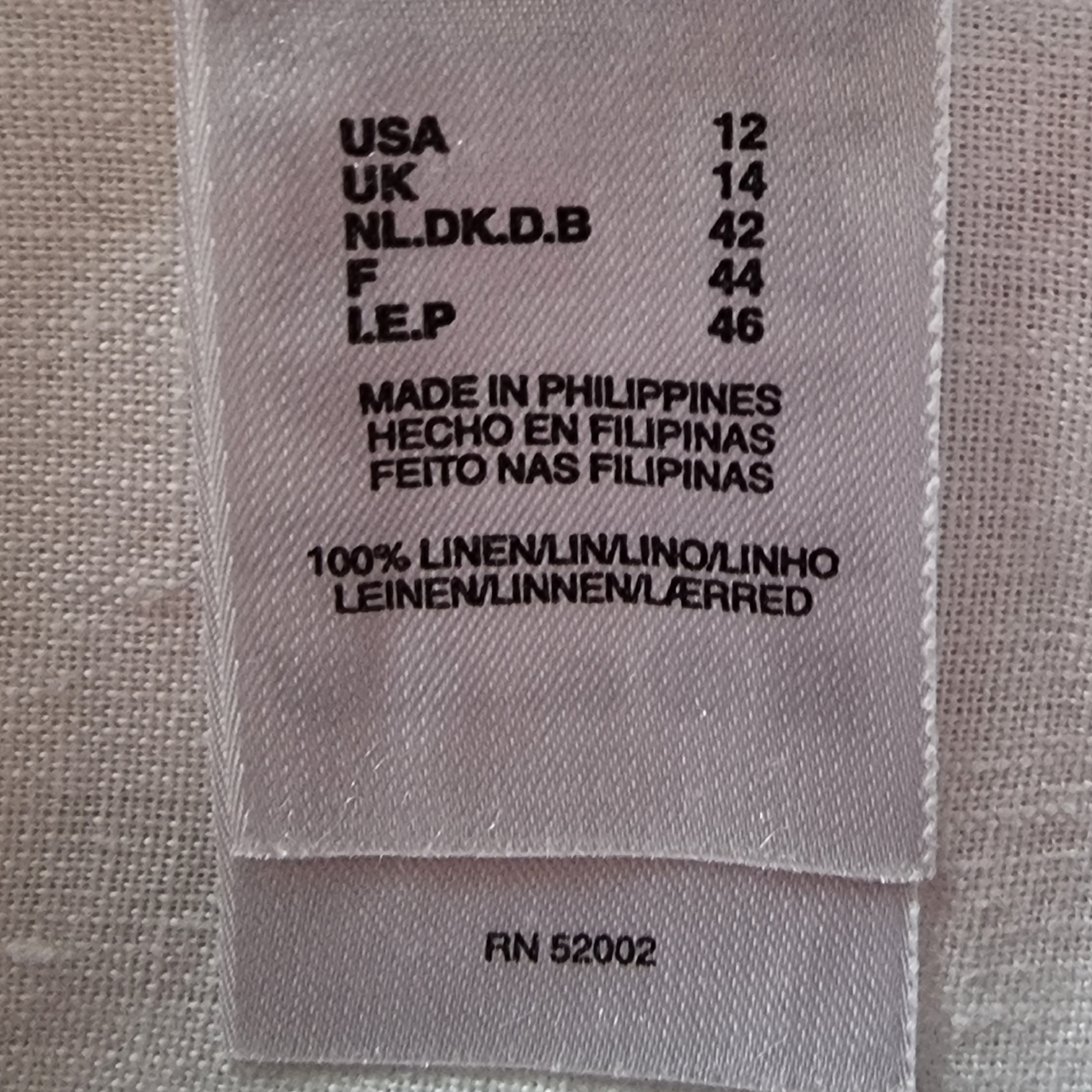 Fabric label with size and origin information on a textured fabric background