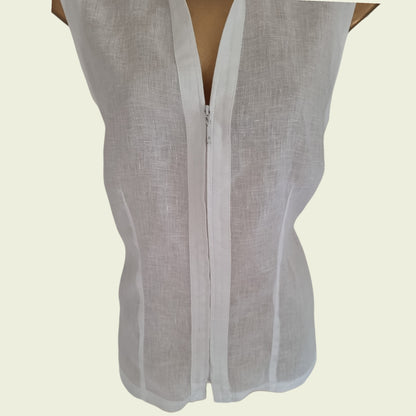 White sleeveless top with zipper on a beige background