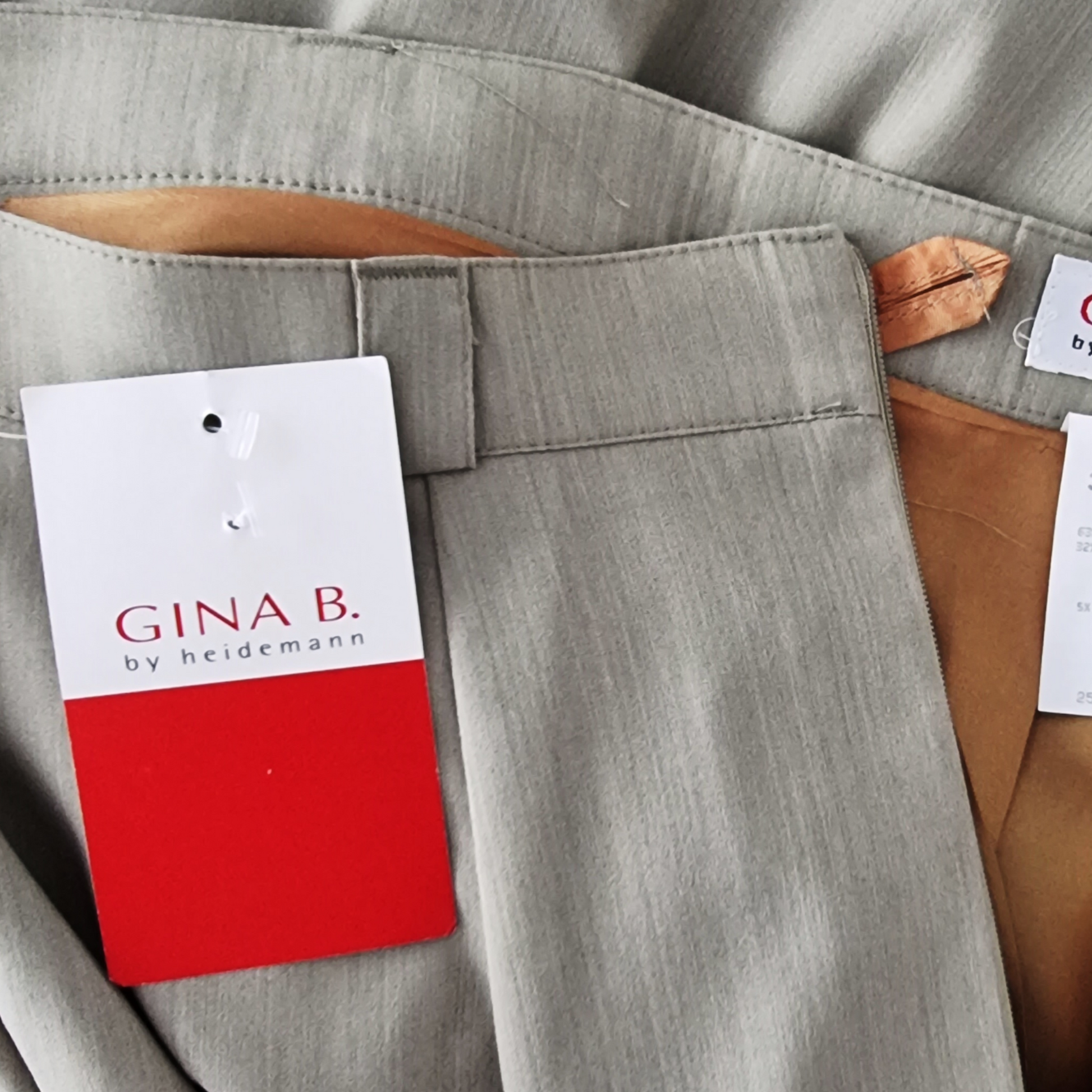 Sage skirt with a Gina B by Heidemann tag on a brown surface