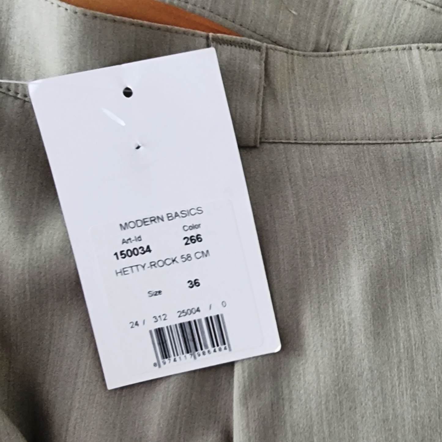 Sage skirt with a label displaying product details