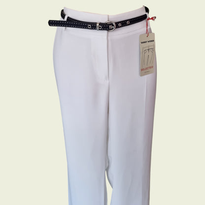 White pants with a navy belt and visible brand tag on a light beige background