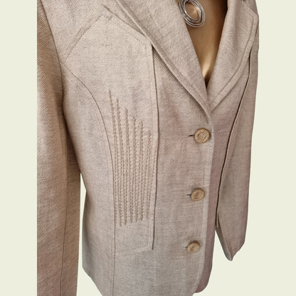 Beige blazer with button details on a light beige background
