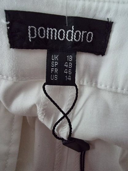 Close-up of a label on a white garment with 'pomodoro' branding.
