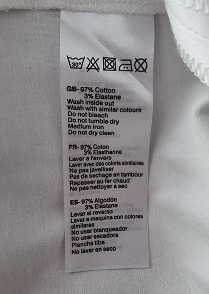 Close-up of a fabric label with washing instructions on a light gray background