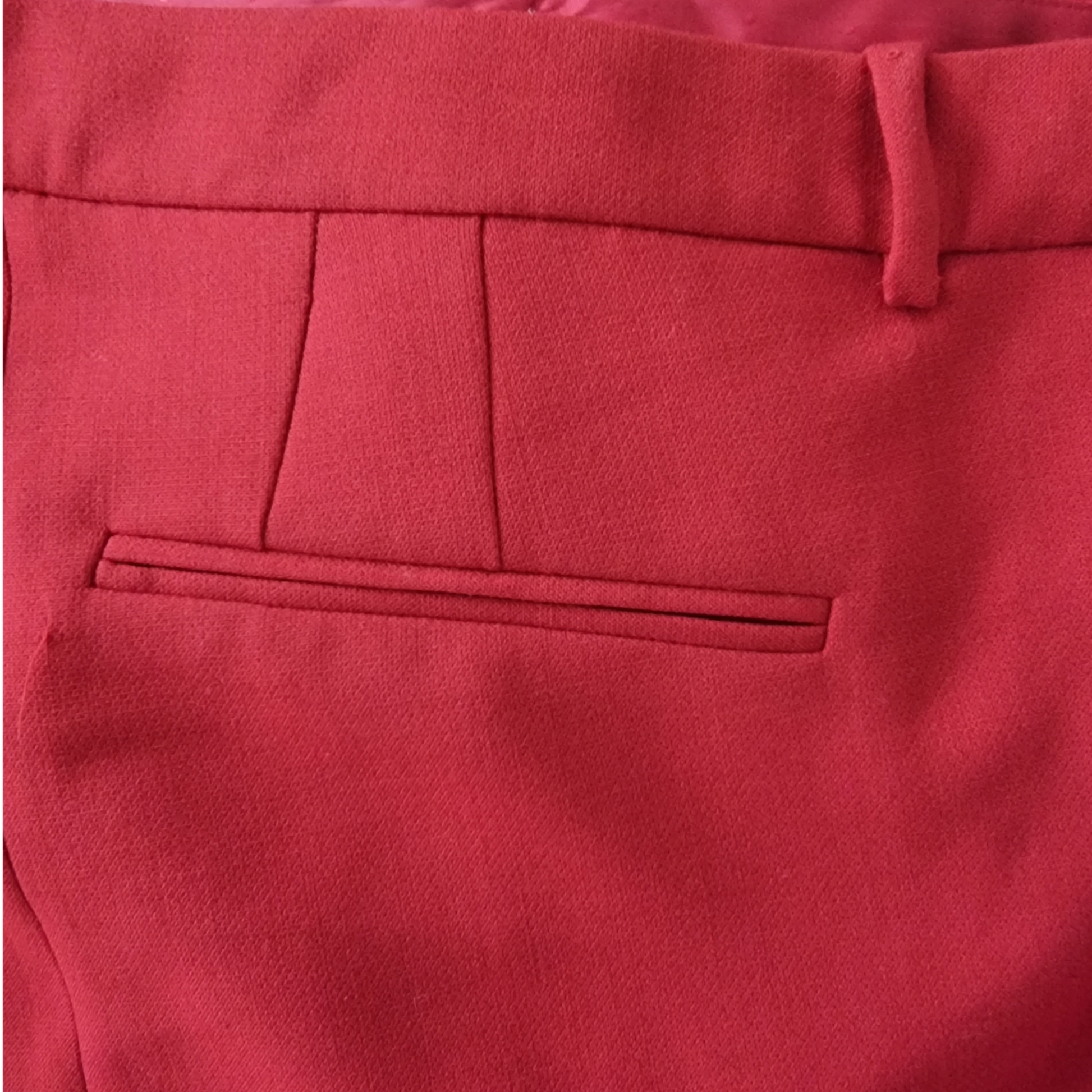 Close-up of red pants with a pocket detail