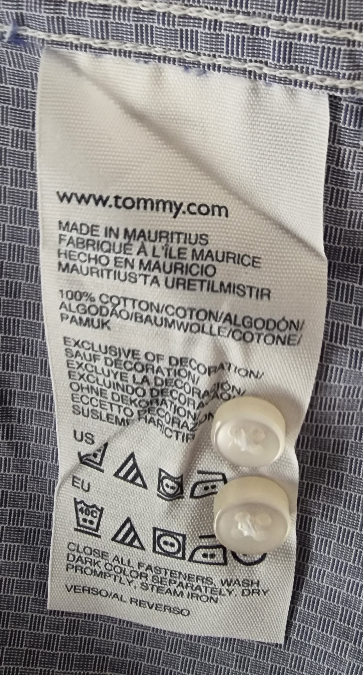 Fabric label with 'Tommy' branding on a textured fabric background
