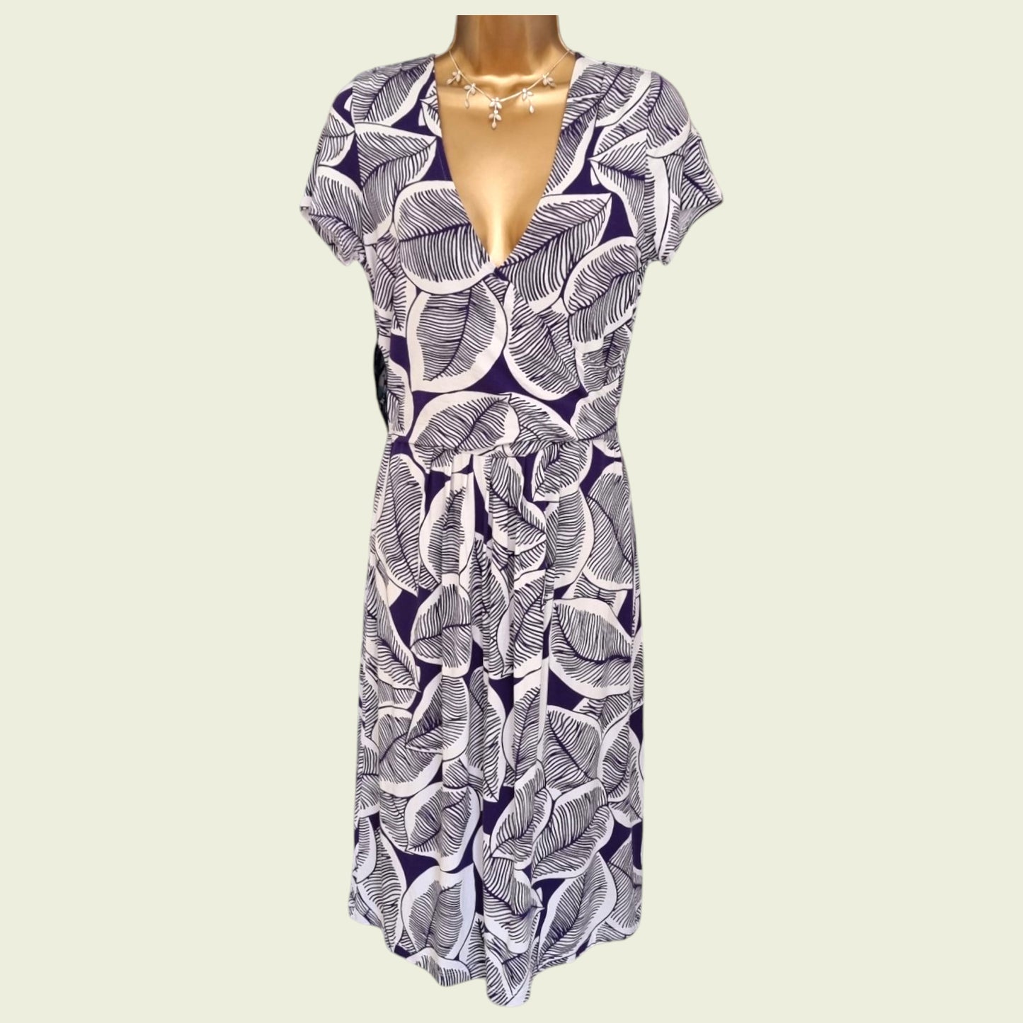 Mannequin wearing a blue and white floral dress on a beige background