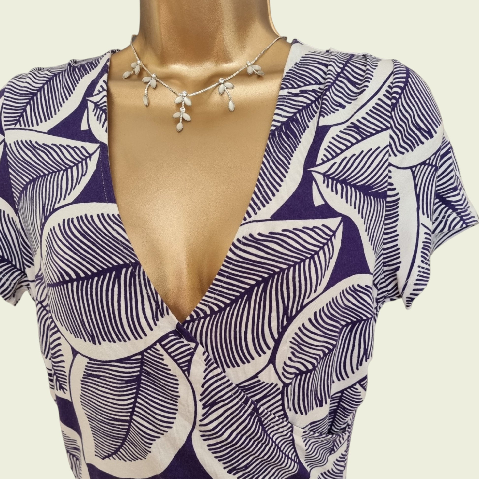 Mannequin wearing a blue and white floral dress on a beige background