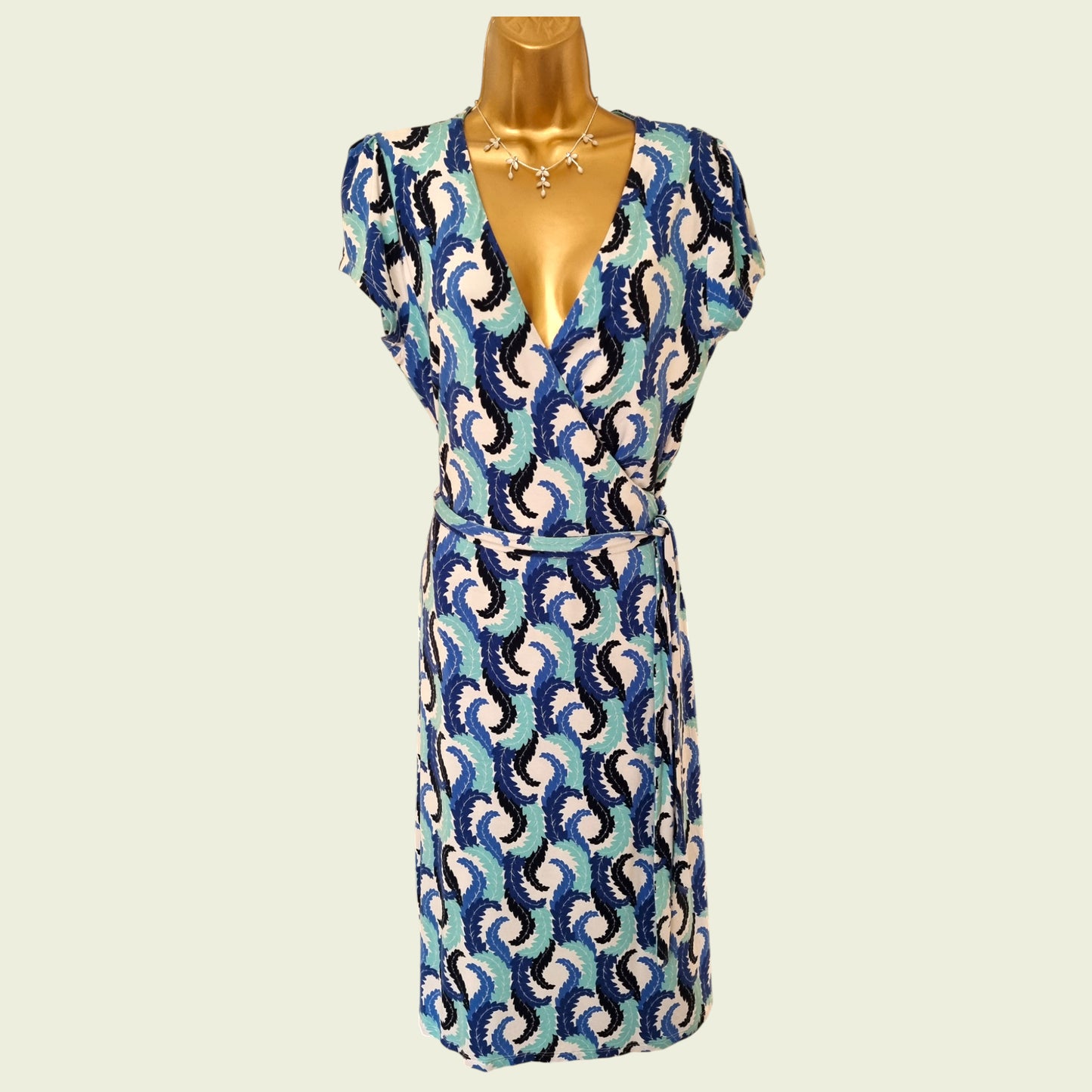 Patterned dress on a mannequin against a plain background
