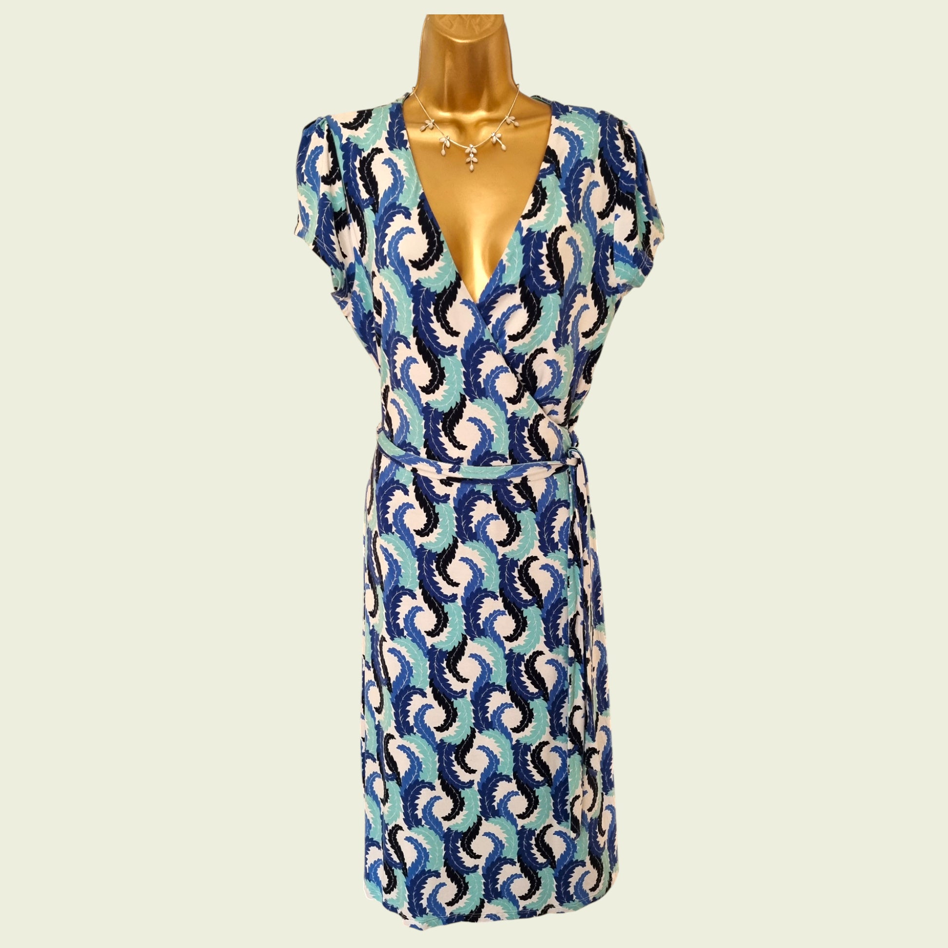 Patterned dress on a mannequin against a plain background