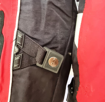 Close-up of a motor cycle jacket with a metal buckle on a red and black background