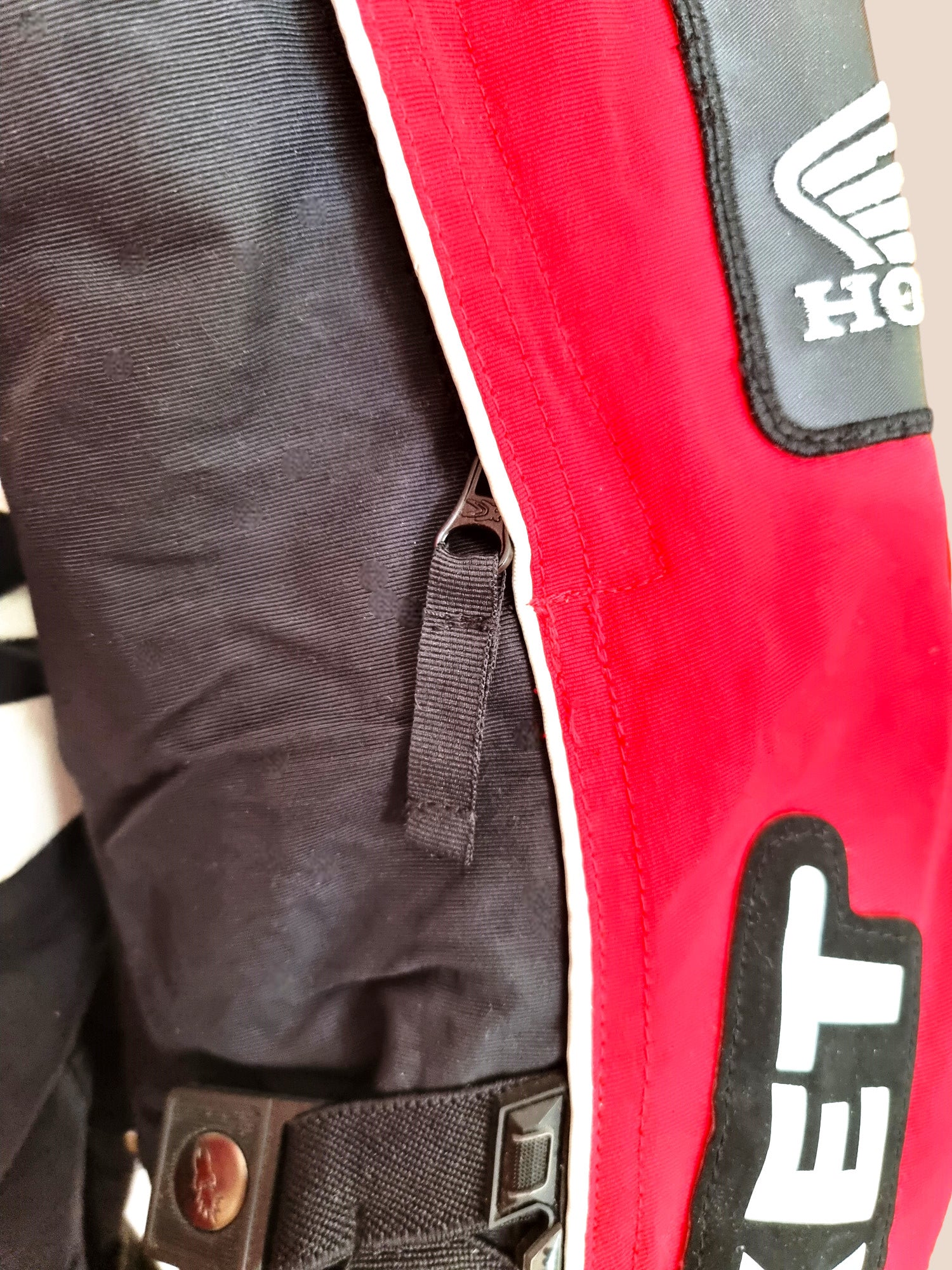 Close-up of a red and black motor cycle jacket with visible branding
