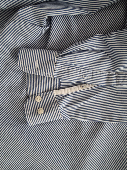 Close-up cuffs of a blue and white striped shirt.