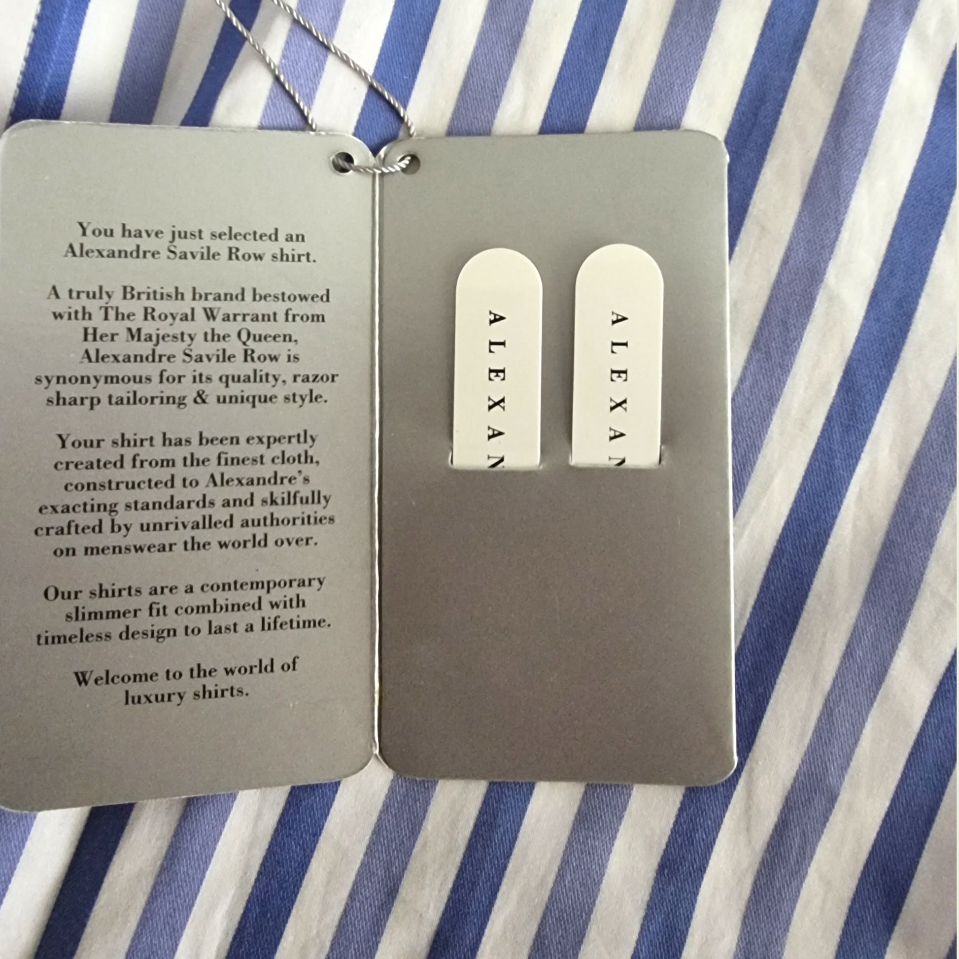 Alexandre Saville Row shirt tags on a striped fabric background