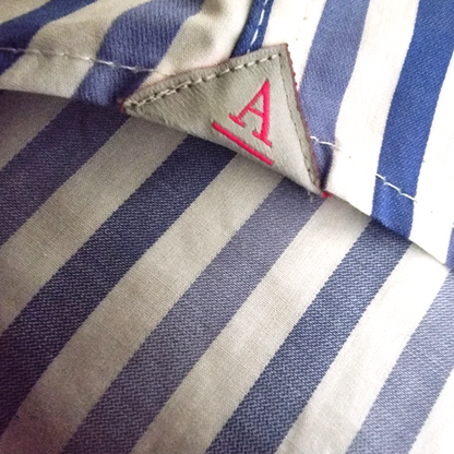 Close-up of a striped fabric with a brand label featuring a red 'A'.