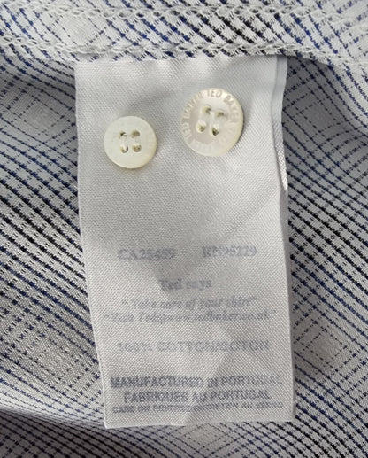 Close-up of a label on a striped shirt with visible text and buttons.