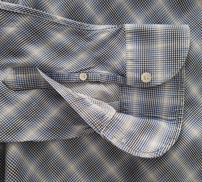 Close-up of a blue and white checkered shirt with folded sleeves.