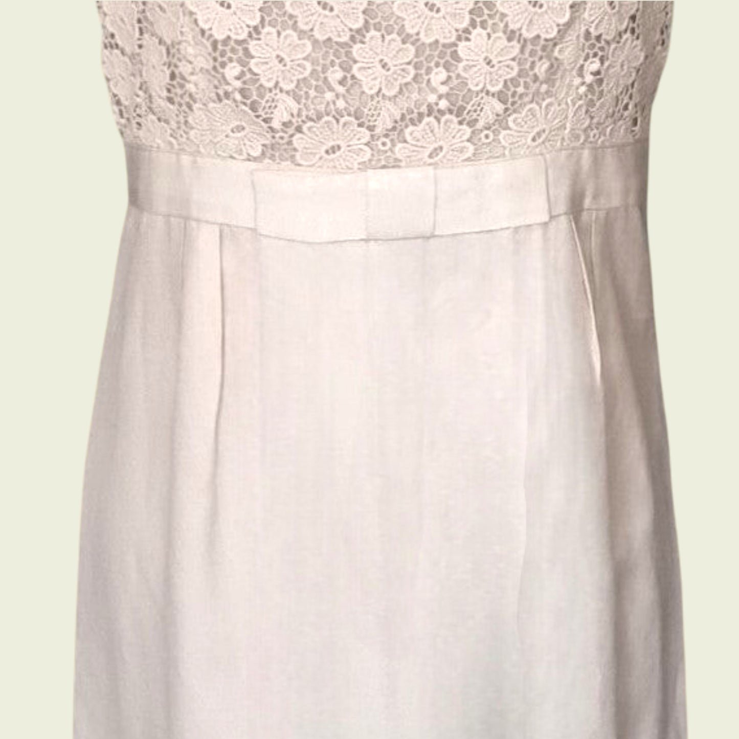 Bow detail on cream dress on beige background